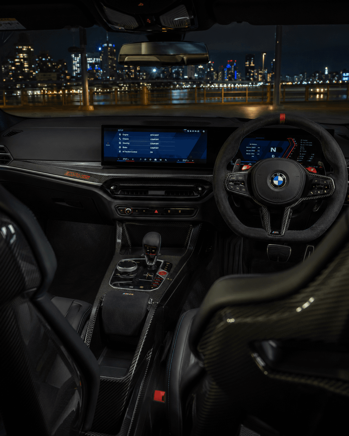 Gece şehir manzarasına bakan sağ direksiyonlu BMW M4 CS kokpiti