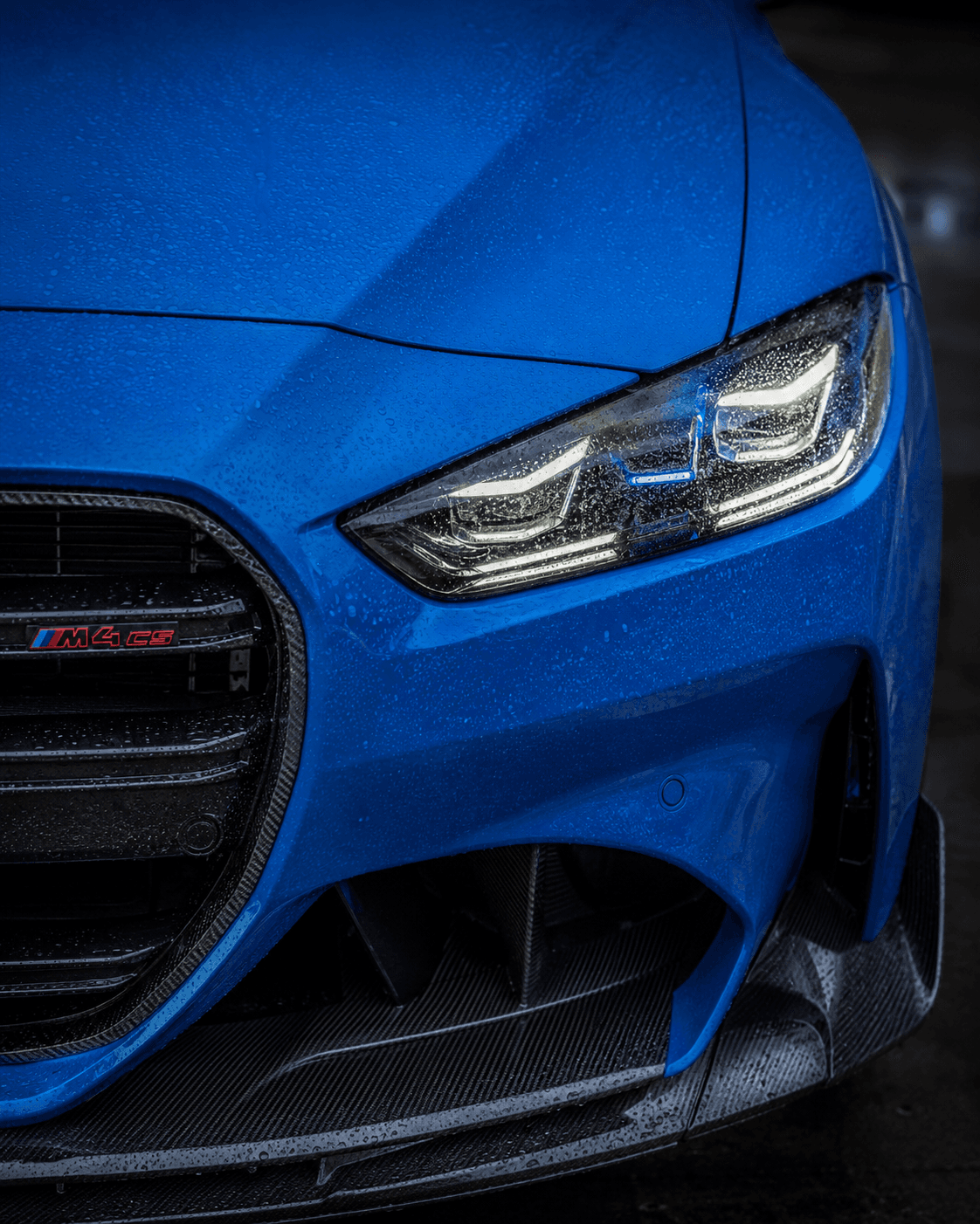 Yağmur damlaları altında BMW M4 CS far ve ön ızgara detayı